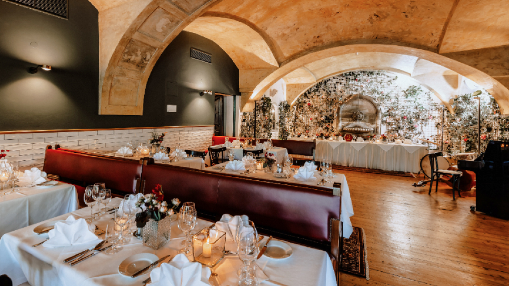 Innenansicht des eleganten Restaurants mit Gewölbedecken und gedeckten Tischen.