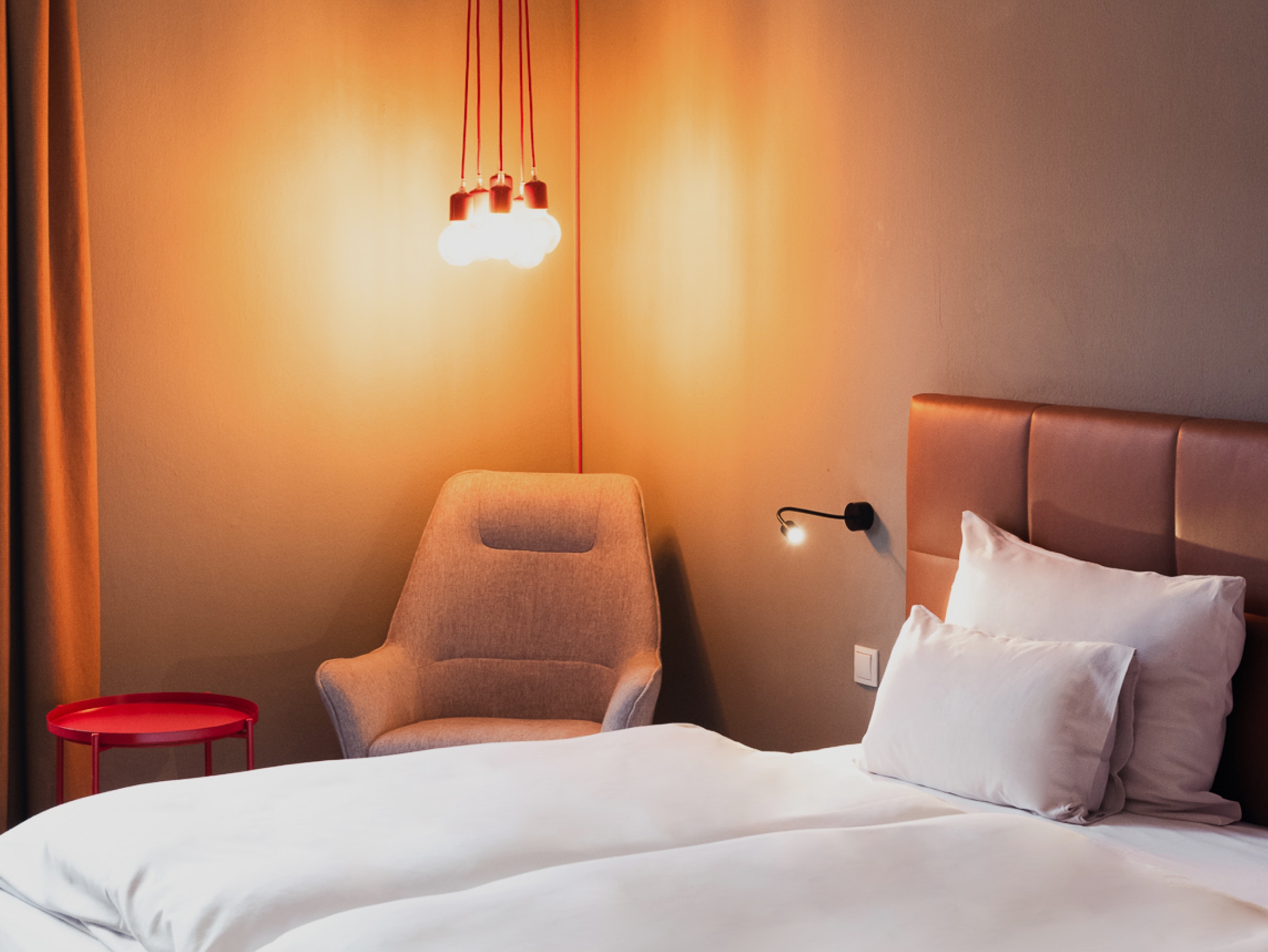 Ein Schlafzimmer mit einem Bett, einem Sessel, einem Tisch und einer Lampe.